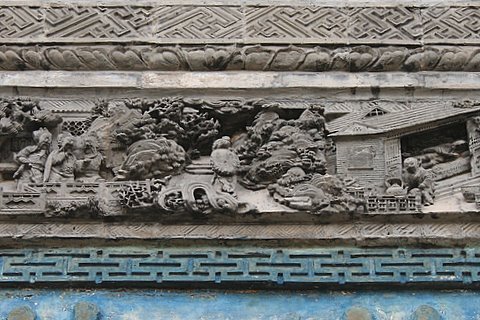 砖雕“三顾茅庐”，左边是刘关张三人，右边躺在房子里的是诸葛亮，烧茶的是书童